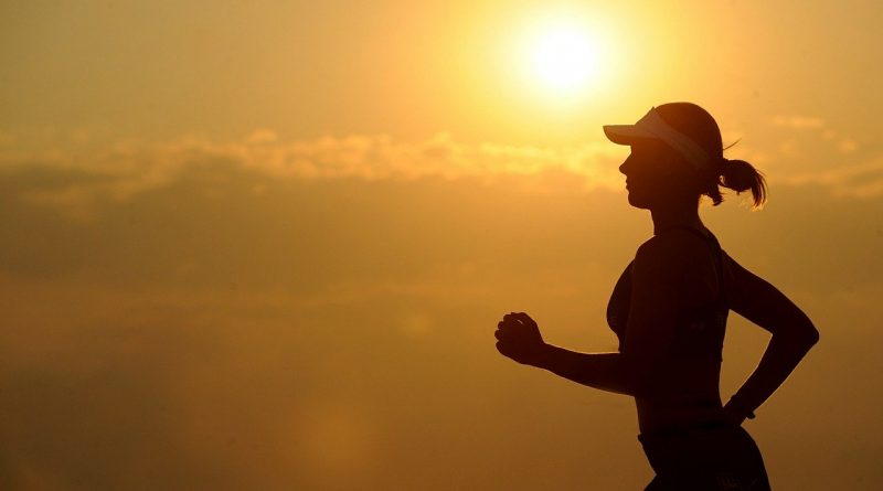 a woman running in the middle of a sunset